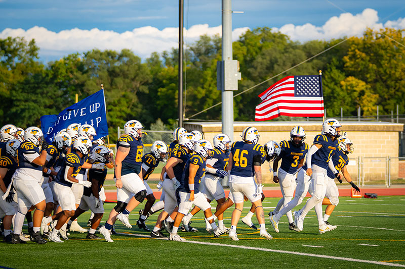 Football players running on the field. Links to Gifts by Will Football players running on the field. Links to Gifts by Will