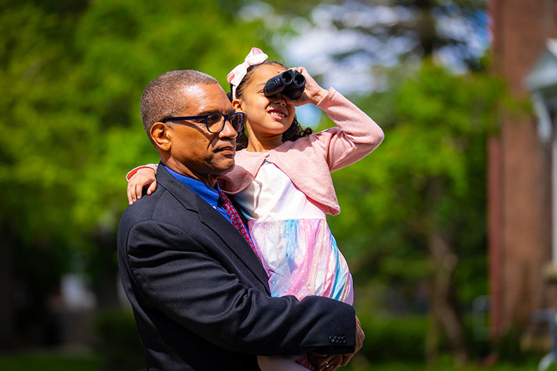 A man carrying a girl with binoculars. Links to Gifts of Appreciated Securities